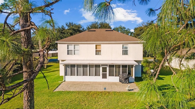 back of house with a lawn and a sunroom