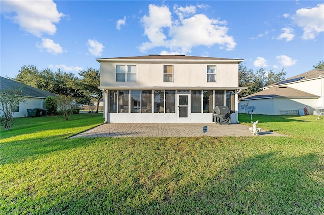 back of house featuring a sunroom and a lawn