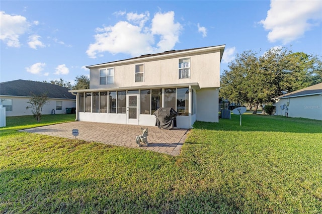 rear view of house featuring a sunroom and a lawn