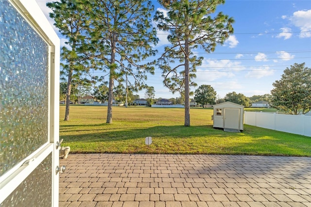 view of yard featuring a shed and a patio area