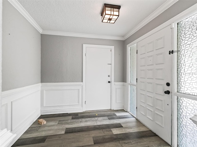 foyer featuring ornamental molding, dark hardwood / wood-style floors, a textured ceiling, and plenty of natural light