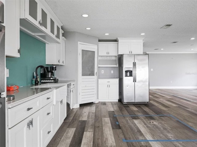 kitchen with white cabinetry, dark wood-type flooring, a textured ceiling, and stainless steel refrigerator with ice dispenser