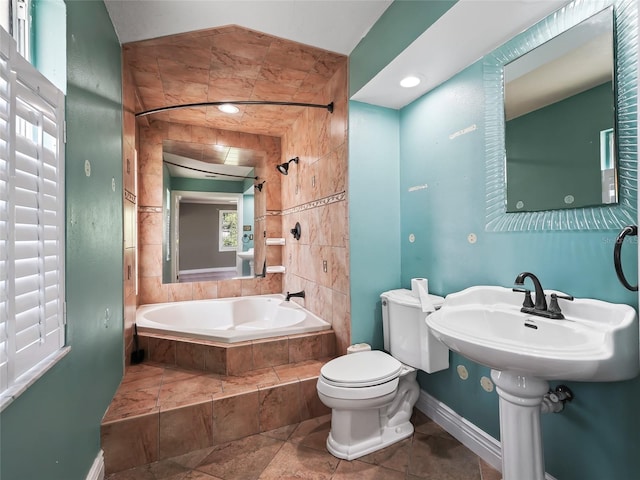 full bathroom featuring toilet, tile patterned flooring, sink, tiled shower / bath combo, and tile walls