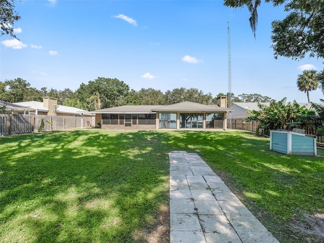 back of property with a sunroom and a lawn