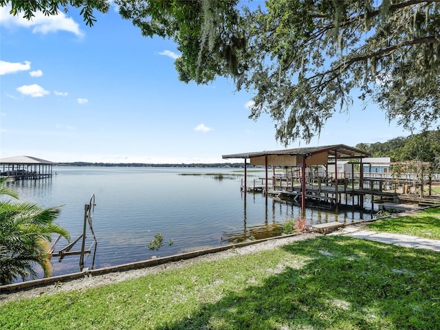 dock area featuring a lawn and a water view