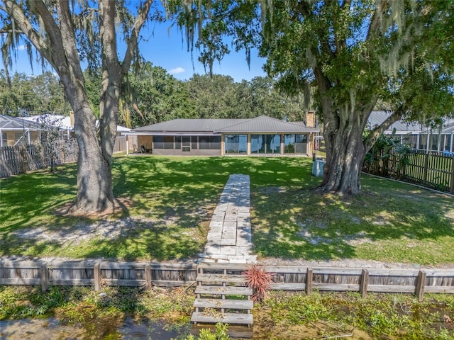 view of front of property featuring a front lawn and a sunroom