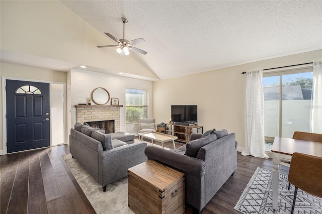 living room featuring dark hardwood / wood-style floors, a wealth of natural light, a fireplace, and vaulted ceiling