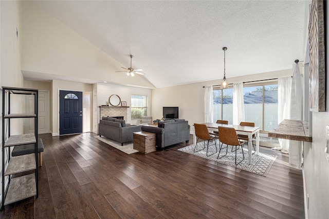 living room featuring a healthy amount of sunlight, high vaulted ceiling, ceiling fan, and dark hardwood / wood-style flooring