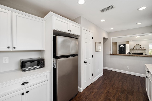 kitchen with stainless steel refrigerator, dark hardwood / wood-style flooring, and white cabinets