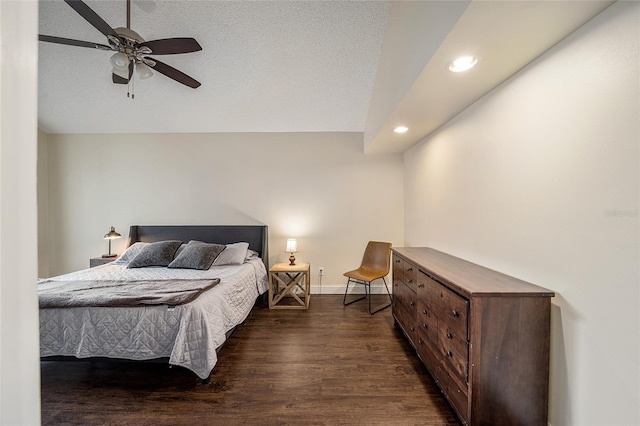 bedroom featuring dark wood-type flooring, a textured ceiling, and ceiling fan