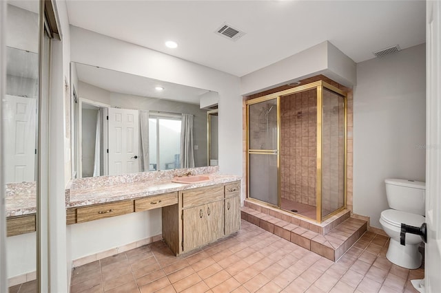 bathroom featuring vanity, a shower with shower door, toilet, and tile patterned floors