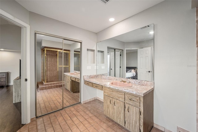 bathroom with vanity and a shower with door