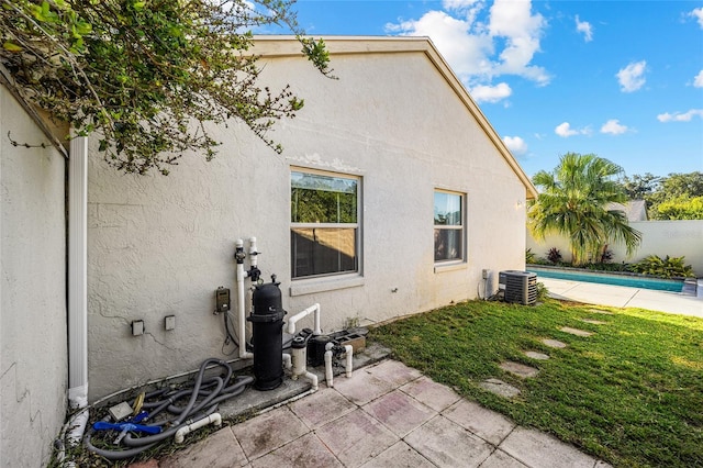 view of property exterior with a patio, a yard, and central air condition unit