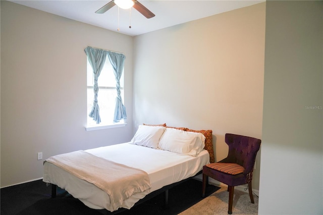 carpeted bedroom with ceiling fan and baseboards