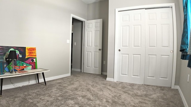 carpeted bedroom with a closet and baseboards