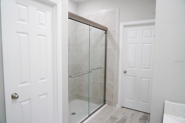 full bath with a shower stall and wood finished floors