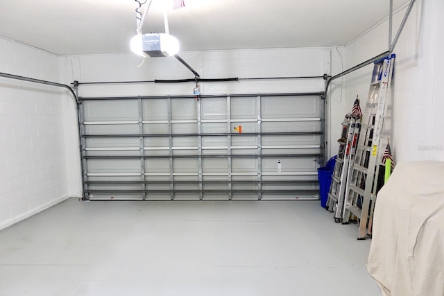 garage with concrete block wall and a garage door opener