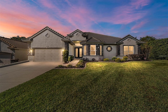 view of front of property with a garage and a yard