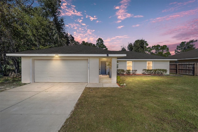 ranch-style house featuring a yard and a garage