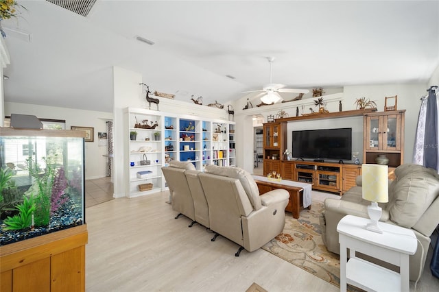 living room with ceiling fan, lofted ceiling, and light wood-type flooring