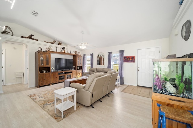 living room featuring ceiling fan, light wood-type flooring, and vaulted ceiling