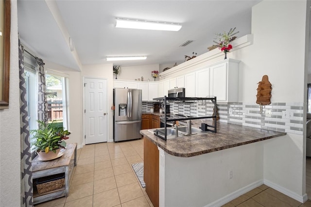 kitchen featuring white cabinetry, backsplash, stainless steel appliances, and kitchen peninsula