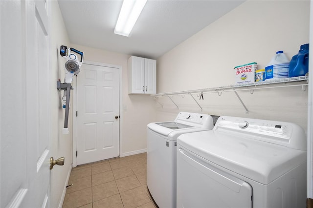 laundry room with cabinets, light tile patterned flooring, and washing machine and clothes dryer