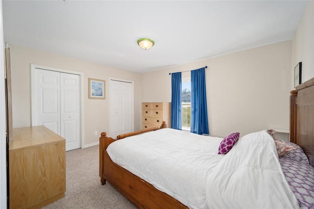 carpeted bedroom featuring multiple closets