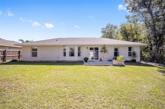 back of property with a patio area and a yard