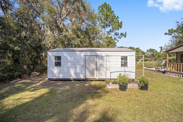 view of outbuilding featuring a lawn