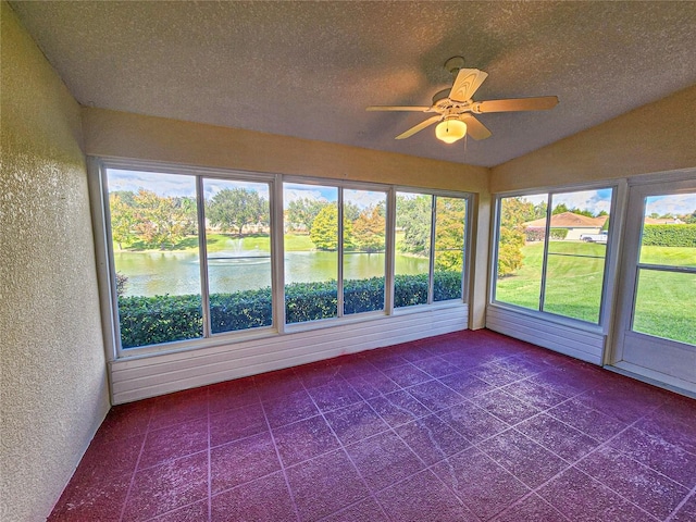 unfurnished sunroom featuring lofted ceiling, a water view, and ceiling fan