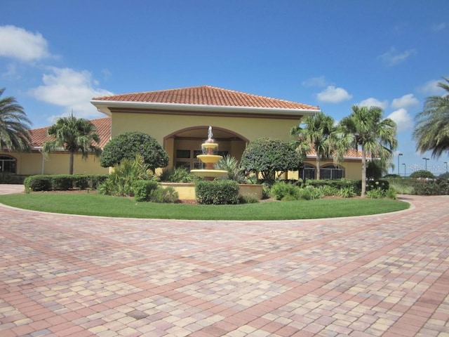 rear view of property with a tiled roof and stucco siding