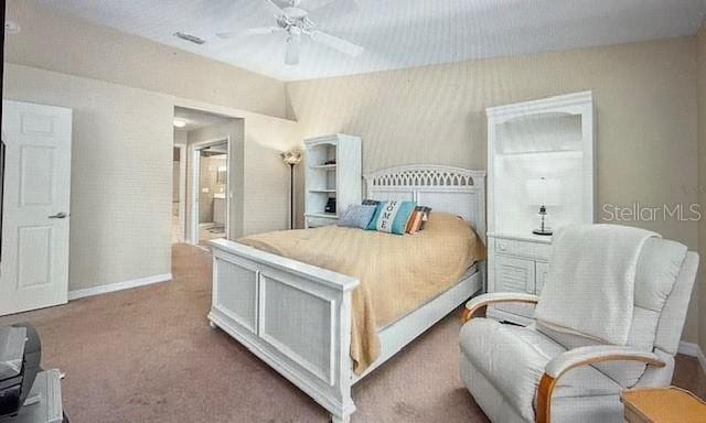 bedroom featuring visible vents, baseboards, ceiling fan, ensuite bathroom, and carpet