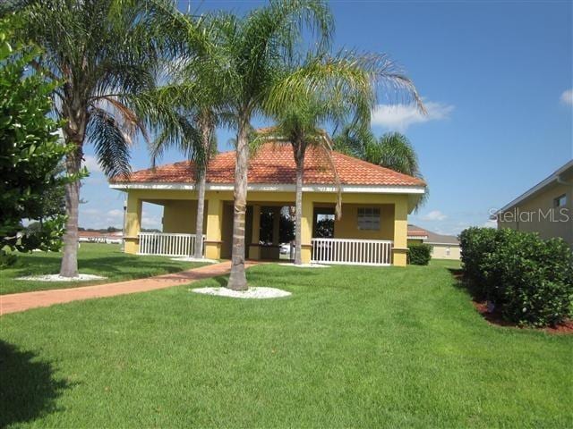 view of front of house with a porch, a front yard, and stucco siding