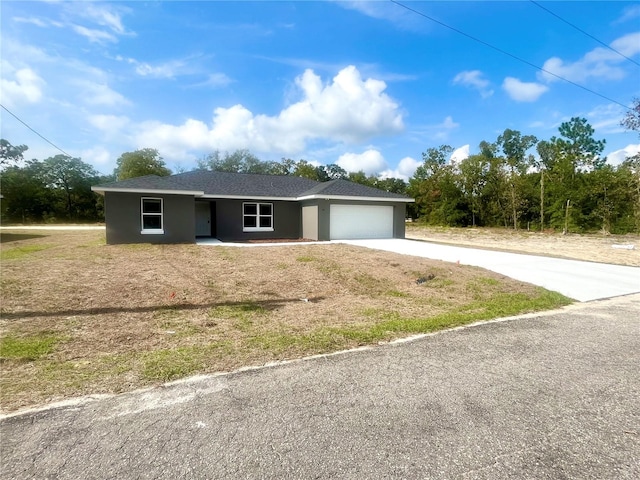 ranch-style house featuring concrete driveway, an attached garage, and stucco siding