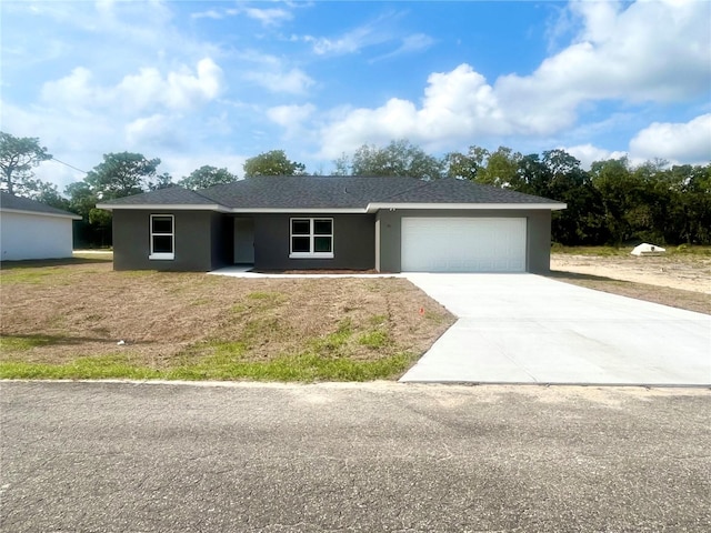 ranch-style house featuring a garage, driveway, and stucco siding