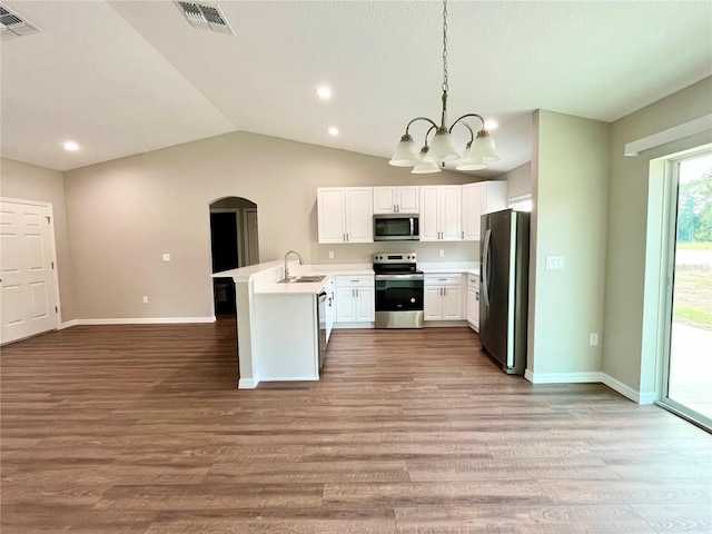 kitchen with stainless steel appliances, a peninsula, white cabinets, light countertops, and pendant lighting