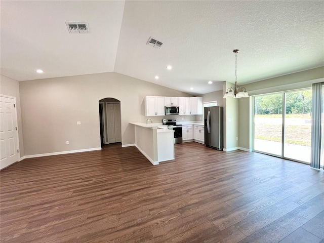 kitchen with light countertops, hanging light fixtures, appliances with stainless steel finishes, open floor plan, and white cabinets