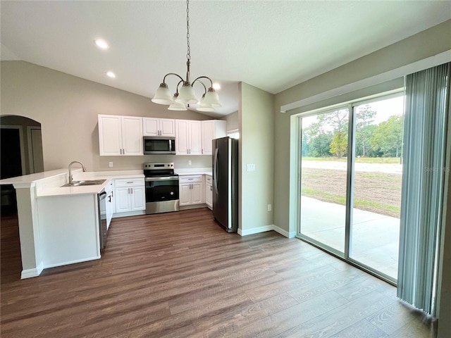 kitchen featuring stainless steel appliances, a peninsula, white cabinets, light countertops, and decorative light fixtures