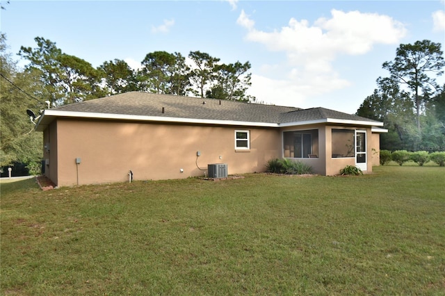 back of house featuring central AC unit and a yard