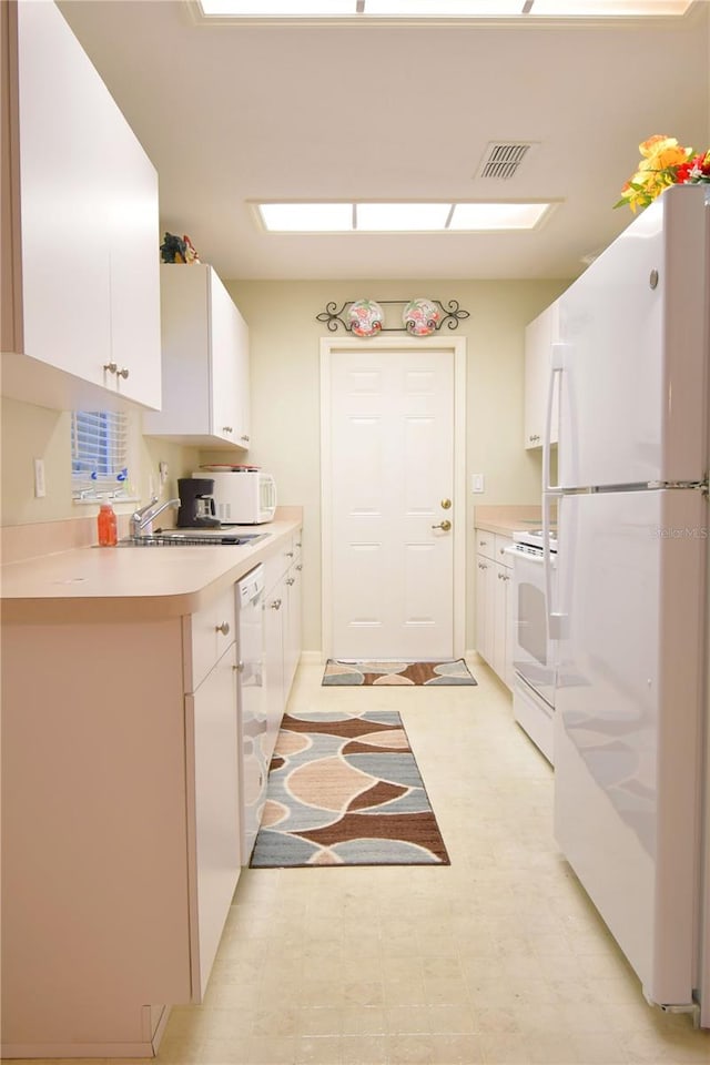 kitchen featuring white appliances and white cabinetry