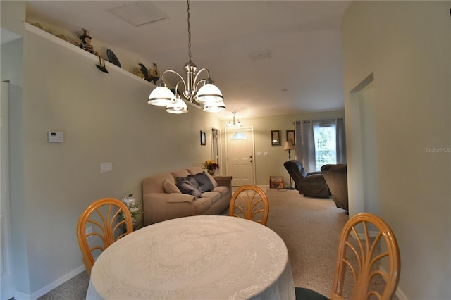 dining room with carpet flooring and a notable chandelier