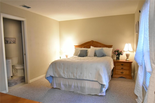 carpeted bedroom with multiple windows and ensuite bath