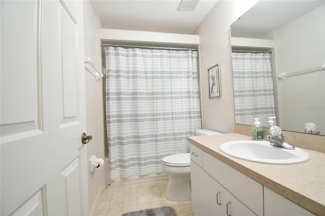 bathroom featuring toilet, vanity, a textured ceiling, and tile patterned floors