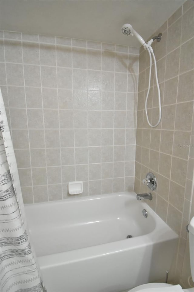 bathroom featuring toilet and shower / bathtub combination with curtain