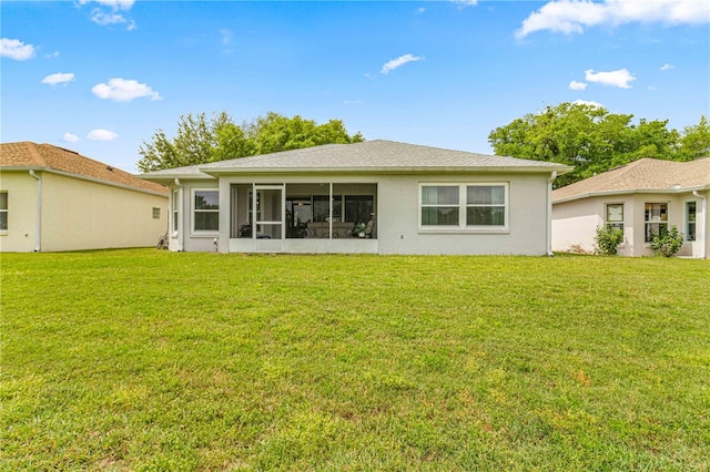 rear view of property with a yard and a sunroom