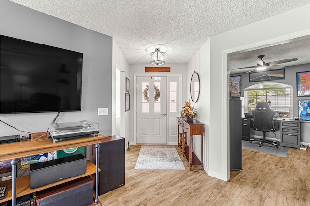 entrance foyer featuring a textured ceiling, light hardwood / wood-style floors, and ceiling fan