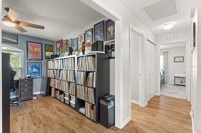 office space featuring ceiling fan, a textured ceiling, and light hardwood / wood-style flooring