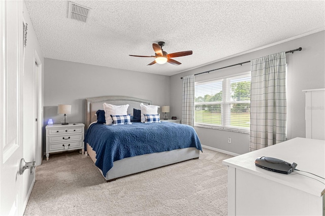 carpeted bedroom with a textured ceiling and ceiling fan