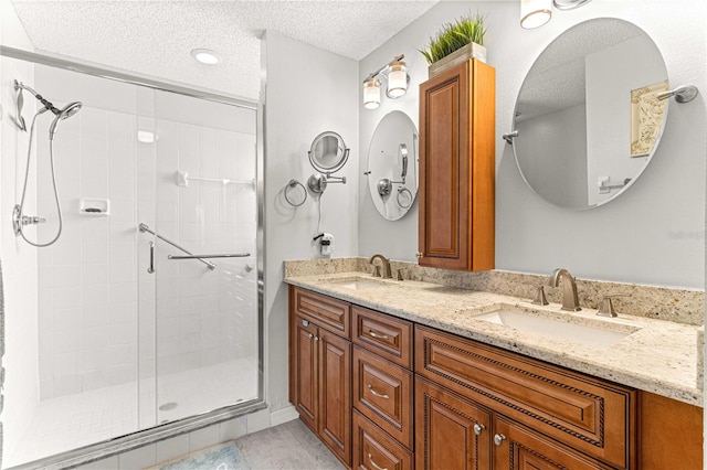 bathroom featuring a shower with door, vanity, a textured ceiling, and tile patterned flooring